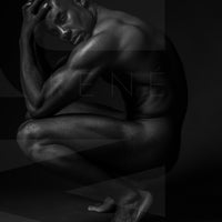 Black and white fine art photo showing a sideview of a nude black man crouching with elbows on knees, hands on head, looking at the camera.
