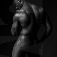 Black and white fine art photo of a nude black man posterior view from head to mid thigh with one arm bent and chin resting on closed fist.
