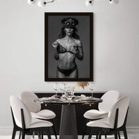 Framed fine art photo hanging in a modern contemporary dining room showing a gorgeous woman wearing a lace bra and panties with a steampunk style captain's hat and round goggles on her head