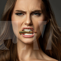 Close up portrait of a beautiful woman holding a bullet between her teeth with her brow furrowed.