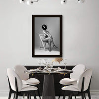 Modern black and white dining room with framed artwork hanging above buffet.