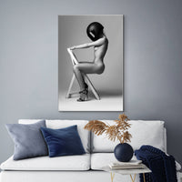 Canvas artwork featuring nude woman wearing motorcycle helmet hanging above a white sofa