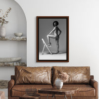 Framed fine art photography of nude woman hanging above brown leather sofa