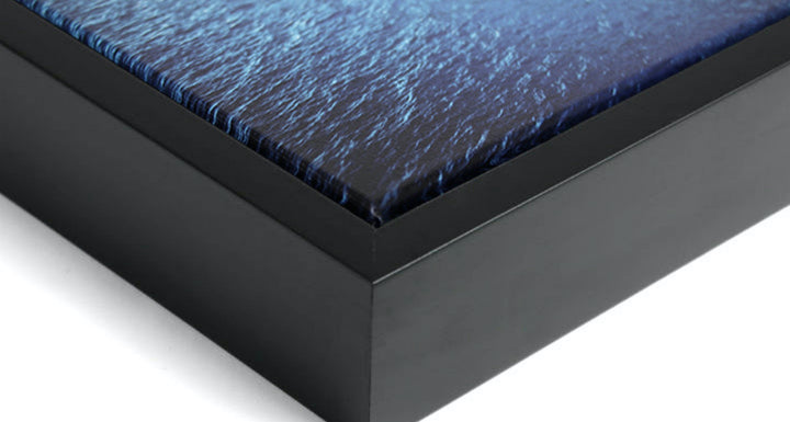 Close up of corner of thin float framed canvas showing the wood frame, canvas and spacing between the two.