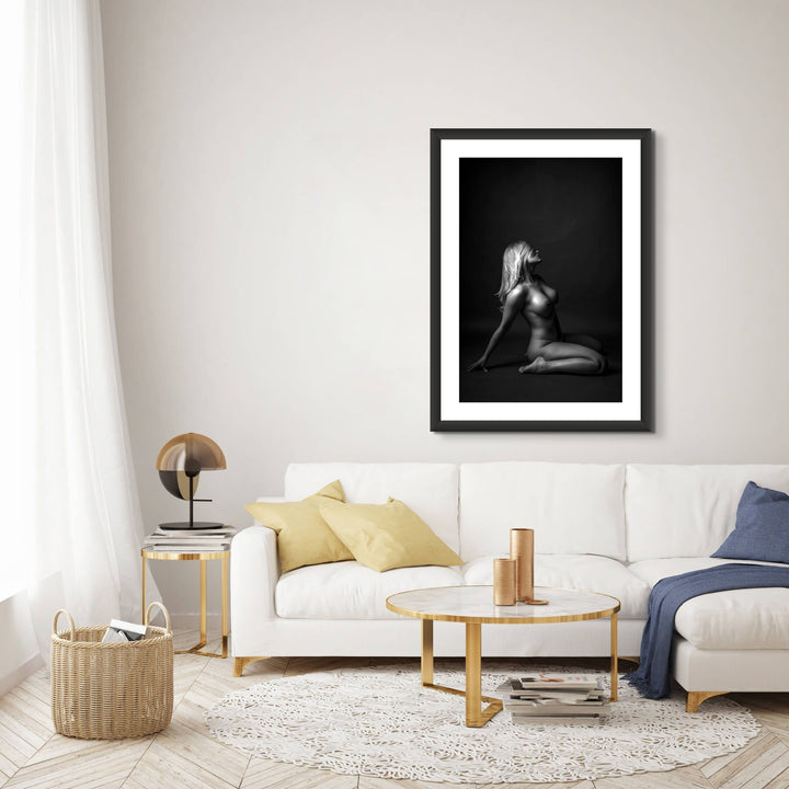 Gorgeous sitting area with framed artwork displaying a beautiful simple photo showing a sideview of a nude woman sitting on her knees, leaning back with her hair swept across her face.