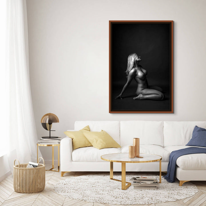 Gorgeous sitting area with oversized walnut float framed canvas displaying a beautiful simple photo showing a sideview of a nude woman sitting on her knees, leaning back with her hair swept across her face.