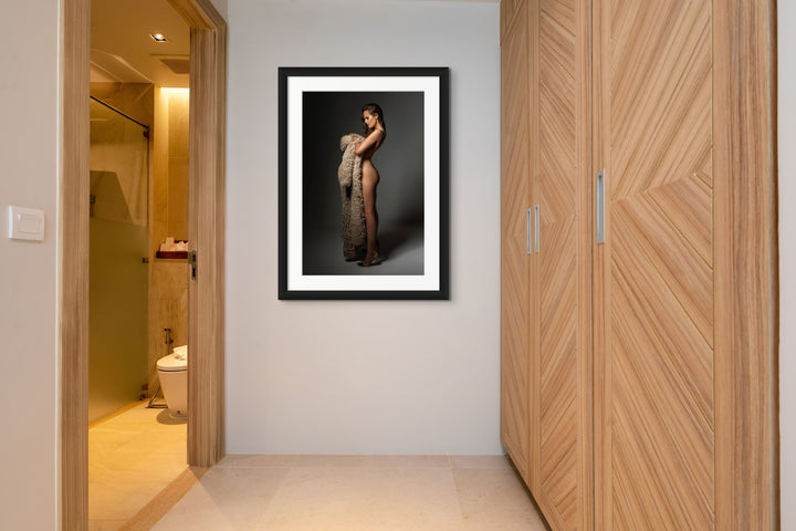 Photo of a closet and entry to an ensuite. On the wall is a framed fine art photo of a sideview of a nude woman wearing high heels looking down at the fur coat she is holding in her arms.