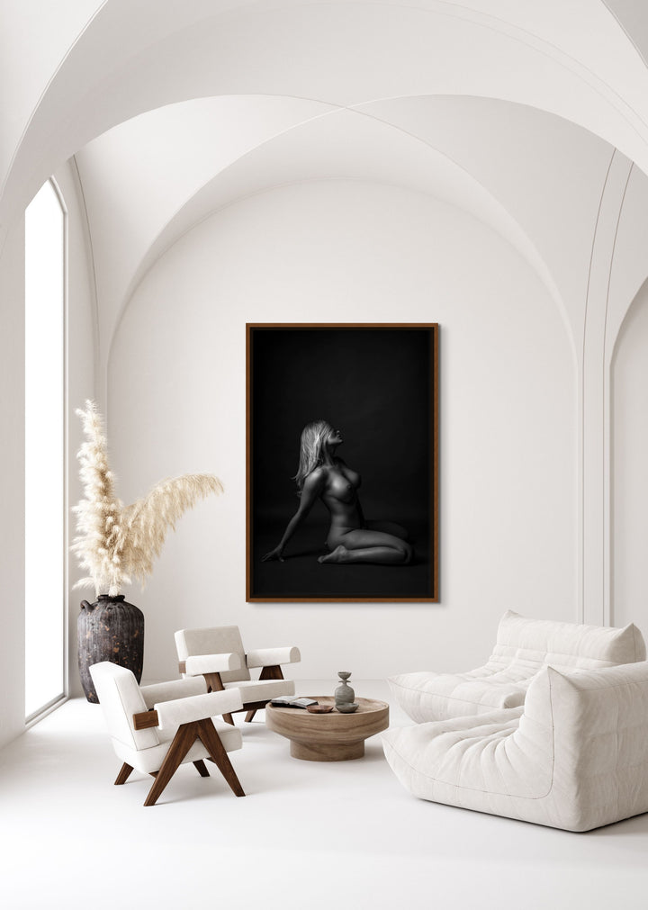 Gorgeous sitting area with oversized walnut float framed canvas displaying a beautiful simple photo showing a sideview of a nude woman sitting on her knees, leaning back with her hair swept across her face.