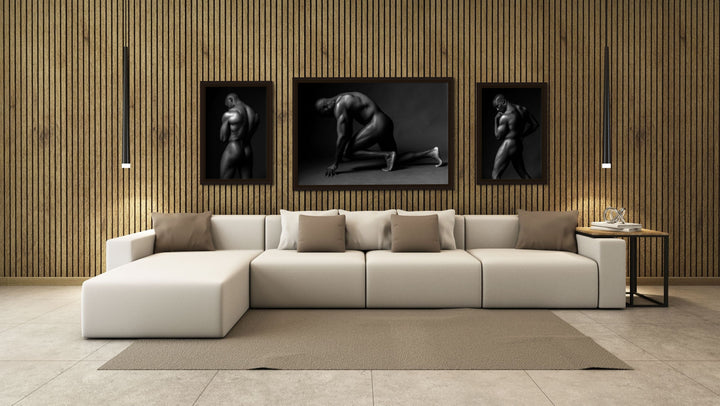 A contemporary living room with three float framed canvases, displaying images of a nude black athletic man. 