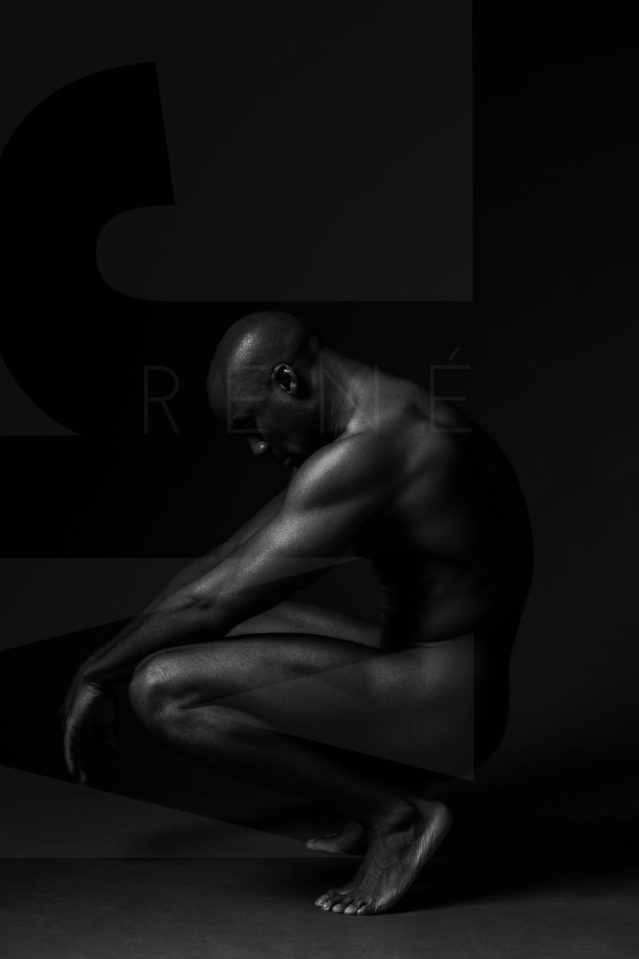 Black and white fine art photo showing a sideview of a nude black man crouching with arms resting on knees and head tilted down.