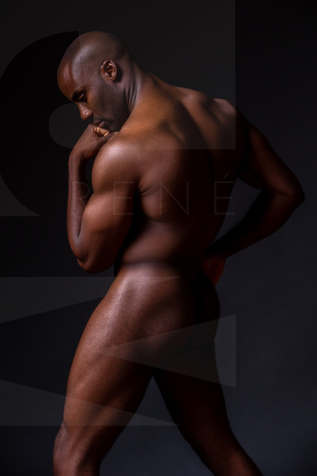 Fine art photo showing a sideview of a nude black man from head to mid thigh with one arm bent and chin resting on closed fist.