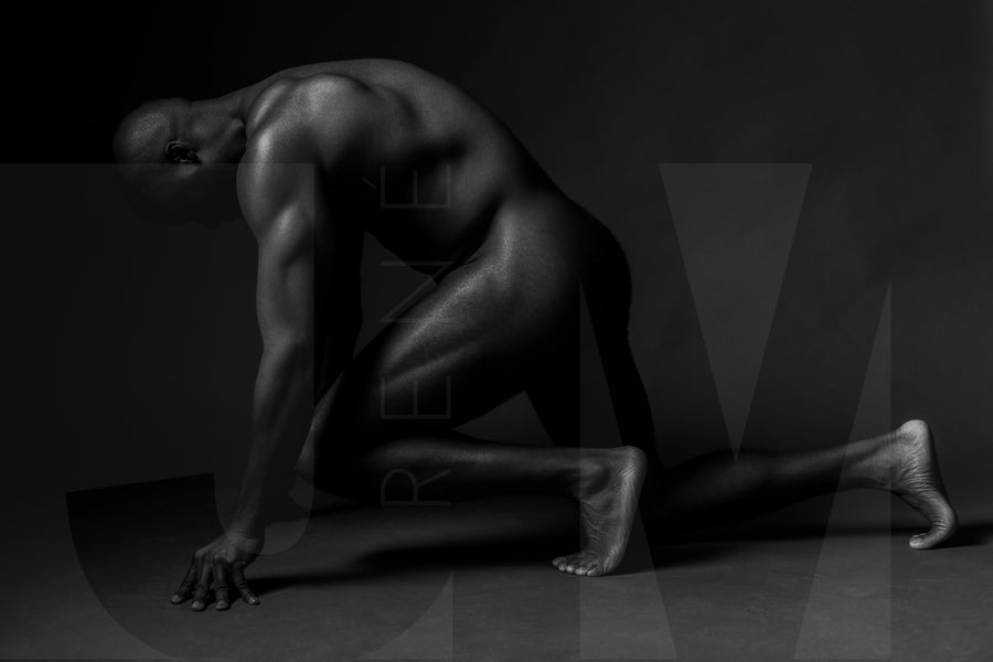 Black and white fine art photo showing a sideview of a nude black man from head to mid thigh with one arm bent and chin resting on closed fist.