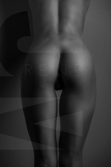 Vertical black and white fine art photo of nude woman from back, showing her naked body from her lower back to her upper thighs with the light reflecting off of her shapely buttocks.