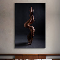 Bedroom wall with picture of nude woman in acrobatic pose hanging above headboard