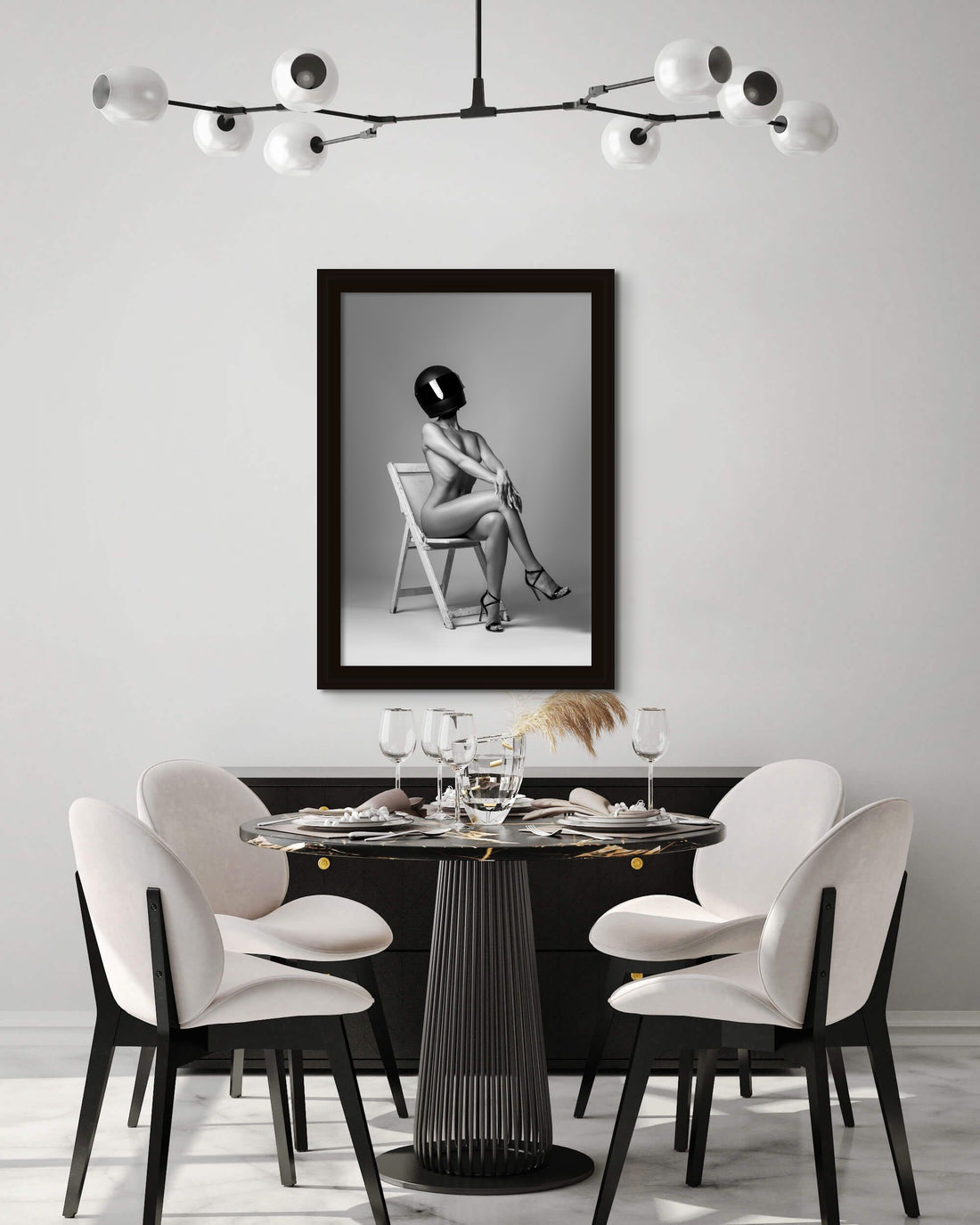 Modern black and white dining room with framed artwork hanging above buffet.
