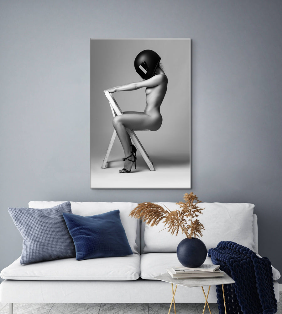 Canvas artwork featuring nude woman wearing motorcycle helmet hanging above a white sofa